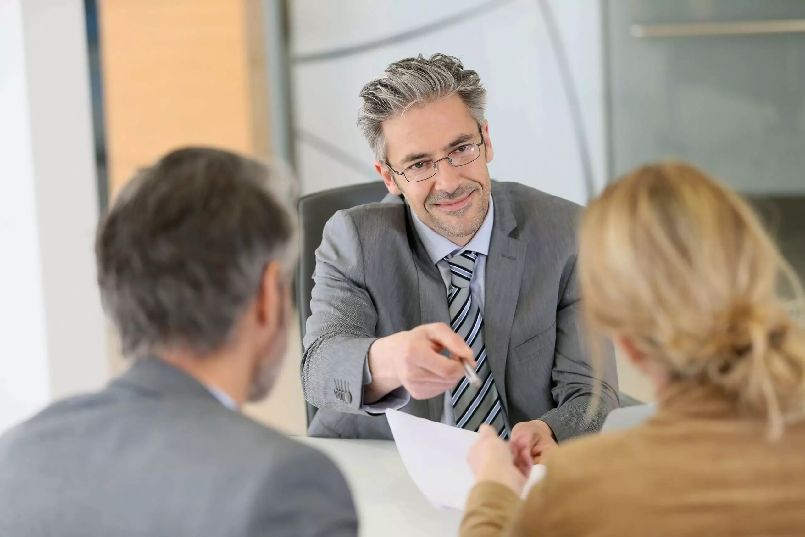 Mature couple signing contract in lawyer's office